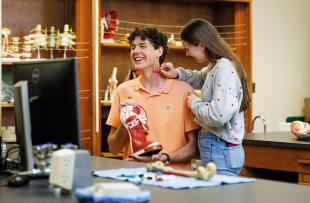 A student draws the muscle in Luke Hansen's neck during a Creative Anatomy club meeting. 