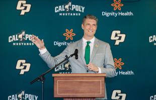 Cal Poly's new athletic director Carter Henderson gestures at a podium during an event announcing his position.