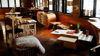 A collection of hand-made furniture items in a sunlit event space. 