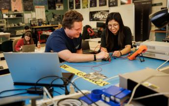 Two students work in the CubeSat lab at Cal Poly.