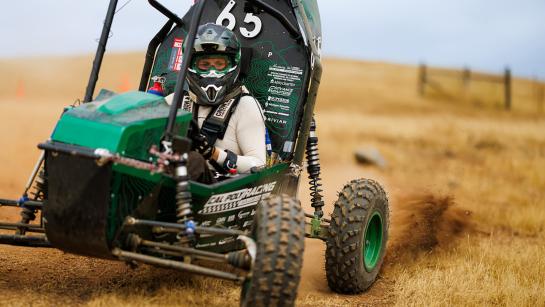 A student driving the Cal Poly Racing Team's Baja racer.