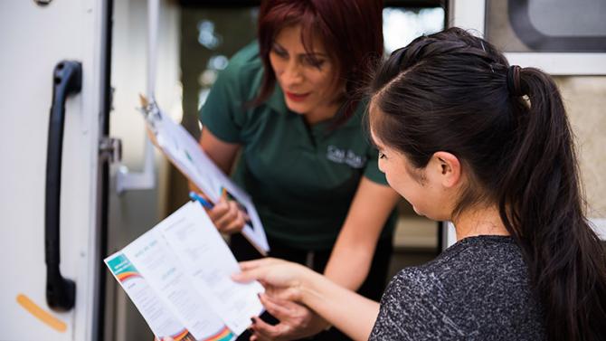 Cal Poly Health Ambassador reading health education literature