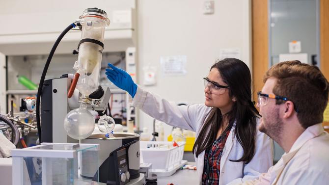 Two Chemistry students conducting pharmaceutical research together in the lab