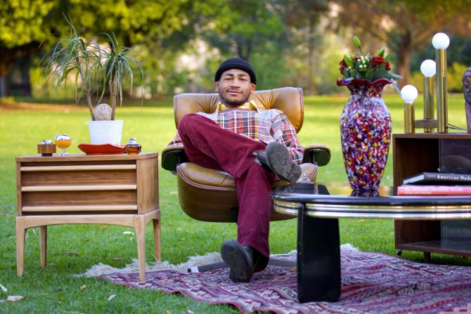 MBA student Adam Kemp sits on a lawn with some vintage furniture finds