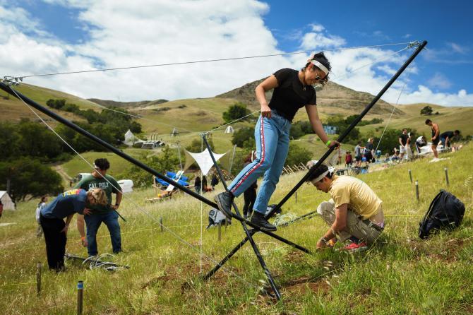 Students work on a design village structure outdoors