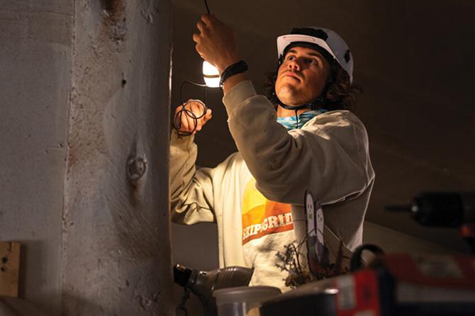 A student installs lighting in a home in the Navajo nation