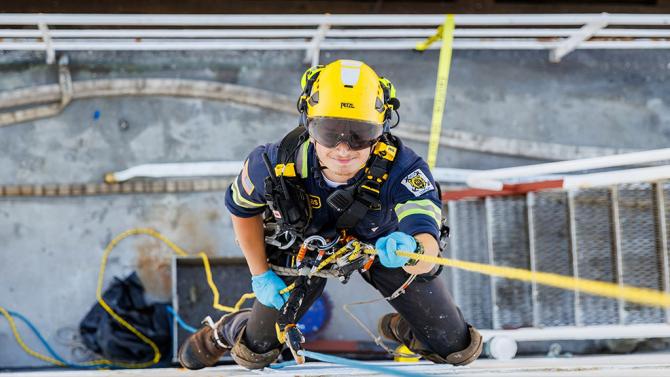 Student scaling the side of a ship