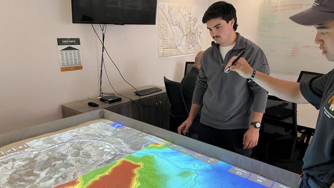 Students using an interactive topographical fire map.