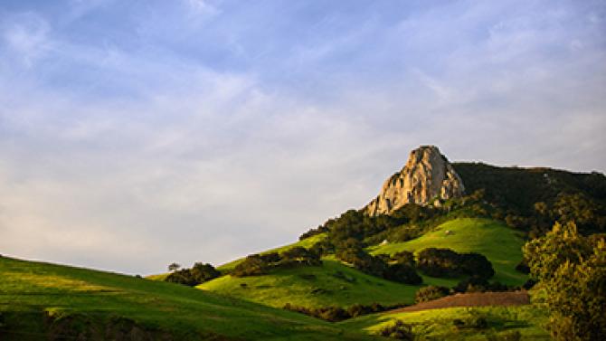 Chumash Peak with green grass and a blue sky.