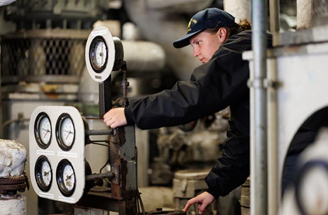 A cadet working in the engine room of Training Ship Golden Bear.