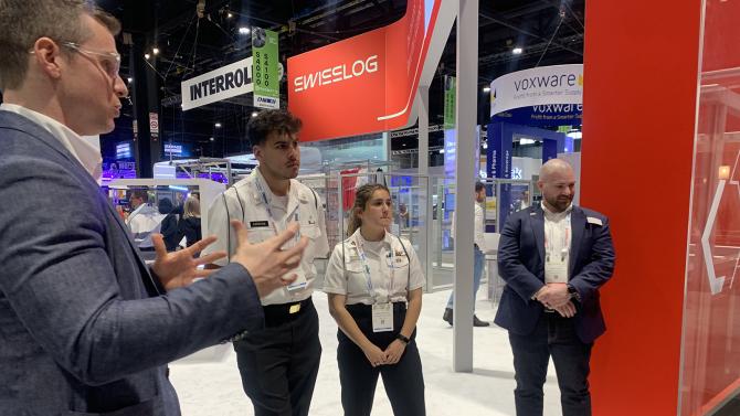Two students talking to two industry reps at a maritime business conference.
