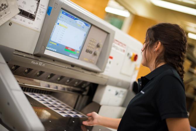 A student using printing machinery at UGS.