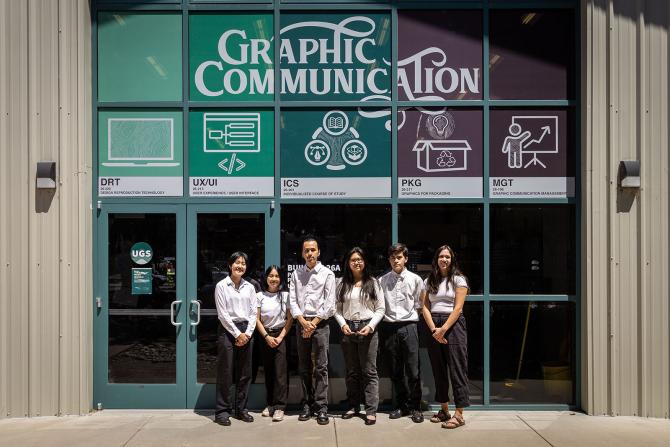Students from the award-winning Phoenix Challenge team standing outside of the Graphic Communication building.