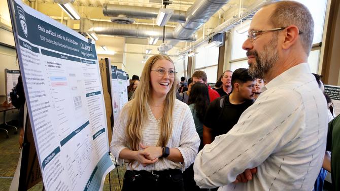 A student presents data science research at a poster session